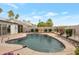 Backyard pool with desert landscaping, featuring a secured surrounding wall and palm trees at 3973 W Hearn Rd, Phoenix, AZ 85053
