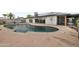 Inviting backyard pool with a patio, desert landscaping, and solar panels at 3973 W Hearn Rd, Phoenix, AZ 85053