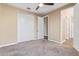 Bedroom features neutral walls, plush carpet, closet with sliding doors, and a ceiling fan at 42213 W Santa Fe St, Maricopa, AZ 85138