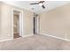 Carpeted bedroom with ceiling fan and views to a bathroom, offering a serene retreat within the home at 42213 W Santa Fe St, Maricopa, AZ 85138