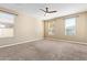 Bright bedroom with neutral walls, plush carpeting, and a modern ceiling fan for added comfort at 42213 W Santa Fe St, Maricopa, AZ 85138