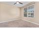 Neutral bedroom featuring a ceiling fan and a window with views of the outside at 42213 W Santa Fe St, Maricopa, AZ 85138