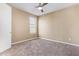 Cozy bedroom featuring neutral walls, plush carpet, a ceiling fan, and a window at 42213 W Santa Fe St, Maricopa, AZ 85138
