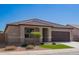 Charming single-story home with desert landscaping, green grass, and a neutral color palette at 42213 W Santa Fe St, Maricopa, AZ 85138