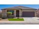 Inviting single-story home with desert landscaping, well-maintained front yard, and a dark brown garage door at 42213 W Santa Fe St, Maricopa, AZ 85138