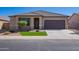 Charming single-story home with desert landscaping, green grass, and a neutral color palette at 42213 W Santa Fe St, Maricopa, AZ 85138