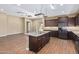 Kitchen with a large island, granite countertops, stainless steel appliances, and dark wood cabinets at 42213 W Santa Fe St, Maricopa, AZ 85138