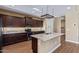 Modern kitchen with dark wood cabinets, granite countertops, stainless steel appliances and a center island at 42213 W Santa Fe St, Maricopa, AZ 85138