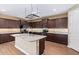 Modern kitchen with a large island, granite countertops, stainless appliances, and dark wood cabinetry at 42213 W Santa Fe St, Maricopa, AZ 85138