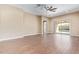 Bright living room with a ceiling fan and sliding glass doors to the backyard at 42213 W Santa Fe St, Maricopa, AZ 85138