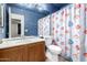 Bathroom featuring a wooden vanity, sink, toilet, and a colorful fish-themed shower curtain at 510 W Amoroso Dr, Gilbert, AZ 85233