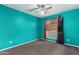 Bright bedroom with ceiling fan, window with blinds, and colorful turquoise accent wall paint at 510 W Amoroso Dr, Gilbert, AZ 85233