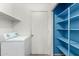 Laundry room with white shelves, blue closet shelves, and a white washing machine at 510 W Amoroso Dr, Gilbert, AZ 85233