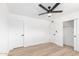 Bright bedroom featuring a ceiling fan, wood-look flooring, and multiple doors at 524 S Pioneer --, Mesa, AZ 85204