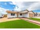 Charming single-story home with fresh landscaping, well manicured lawn, and a neatly bricked walkway at 524 S Pioneer --, Mesa, AZ 85204