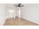 Bright living room featuring wood floors, a modern ceiling fan, and freshly painted white walls at 524 S Pioneer --, Mesa, AZ 85204