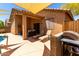 Backyard view of covered patio with ample seating and a stainless steel BBQ grill at 5401 S Dove Holw, Buckeye, AZ 85326