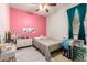 Bright bedroom features a ceiling fan, unique pink accent wall, and a large window at 5401 S Dove Holw, Buckeye, AZ 85326