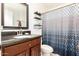 Lovely bathroom featuring an updated vanity, mirror, and modern shower curtain at 6426 W Lamar Rd, Glendale, AZ 85301