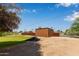 Large backyard with a grass area, metal shed, trees, and a fence at 645 S Esquire Way, Mesa, AZ 85202