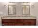 Dual vanity bathroom with granite countertop, framed mirrors, and dark wood cabinets at 645 S Esquire Way, Mesa, AZ 85202