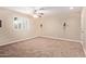 A brightly lit bedroom featuring carpet floors, neutral walls, and a ceiling fan at 645 S Esquire Way, Mesa, AZ 85202