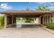 Covered carport with ample space, featuring brick accents, mature greenery, and access to the main house at 645 S Esquire Way, Mesa, AZ 85202