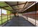 Spacious covered stalls for horses or livestock with metal fencing and partial rubber floor covering at 645 S Esquire Way, Mesa, AZ 85202