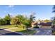 Beautiful single-level home with a well-manicured lawn, mature trees, and a circular driveway leading to a garage at 645 S Esquire Way, Mesa, AZ 85202