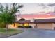 Well-maintained single-story home with a lush front yard, mature trees, and a circular driveway leading to a garage at 645 S Esquire Way, Mesa, AZ 85202