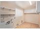 Functional laundry room with ample shelving, white cabinets, and a sink for convenience at 645 S Esquire Way, Mesa, AZ 85202
