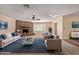 Bright living room features a stone fireplace, ceiling fan, neutral tones and large windows with plantation shutters at 645 S Esquire Way, Mesa, AZ 85202
