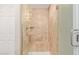 Walk in shower featuring glass door, seating, and decorative beige tile at 645 S Esquire Way, Mesa, AZ 85202