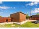Metal storage shed in the backyard with exterior access and adjacent to a grass area and fencing at 645 S Esquire Way, Mesa, AZ 85202