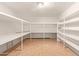 Large walk-in closet featuring built in shelving and tan tiled floor at 645 S Esquire Way, Mesa, AZ 85202
