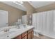 Bathroom featuring a dual sink vanity with framed mirror, toilet, and shower with white curtain at 704 E Gemini Pl, Chandler, AZ 85249
