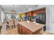 Open-concept kitchen and dining area with wood cabinets, an island, stainless steel appliances and modern pendant lighting at 704 E Gemini Pl, Chandler, AZ 85249