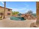 A backyard pool features a rock waterfall and mature landscaping perfect for outdoor living at 704 E Gemini Pl, Chandler, AZ 85249