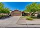 Charming single-story home with a two-car garage, green lawn, and mature shade trees at 7346 E Naranja Ave, Mesa, AZ 85209