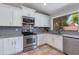 Well-lit kitchen featuring granite countertops, stainless steel appliances, and white cabinets at 7346 E Naranja Ave, Mesa, AZ 85209