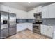 Bright kitchen with stainless steel refrigerator, range, microwave, white cabinets, and granite countertops at 7346 E Naranja Ave, Mesa, AZ 85209