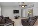 Spacious living room featuring tile flooring, ceiling fan, TV, and comfortable leather seating at 7346 E Naranja Ave, Mesa, AZ 85209