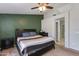 Bedroom featuring a decorative green accent wall, ceiling fan, and neutral carpeting at 7346 E Naranja Ave, Mesa, AZ 85209
