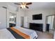 Bedroom featuring a flat-screen TV, ceiling fan, decorative mirror, and ensuite bathroom at 7346 E Naranja Ave, Mesa, AZ 85209