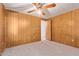 Bedroom with wood paneled walls, neutral carpet, and closet at 7654 E Calypso Ave, Mesa, AZ 85208