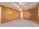 Bedroom with wood paneling, neutral carpet, and a ceiling fan at 7654 E Calypso Ave, Mesa, AZ 85208