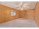 Spacious bedroom featuring wood paneled walls and neutral carpeting at 7654 E Calypso Ave, Mesa, AZ 85208