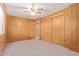 Bedroom with wood paneled walls, neutral carpet, and closet at 7654 E Calypso Ave, Mesa, AZ 85208