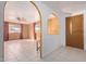 Bright entryway with tile flooring, wood-paneled walls, and arched openings, creating a welcoming space at 7654 E Calypso Ave, Mesa, AZ 85208