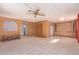 Open living room featuring tile floors, wood paneled walls, ceiling fan, and built in cabinets at 7654 E Calypso Ave, Mesa, AZ 85208